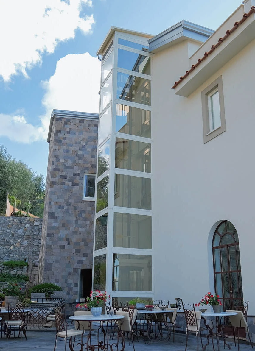 Ascensore in castelletto metallico panoramico adiacente alla villa di lusso