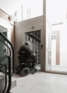 uomo su sedia a rotelle che entra in ascensore