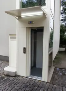 Accesso esterno di una piattaforma elevatrice con cabina in plalam bianco
